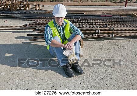 Stock Photograph - worker taking break in construction site. Fotosearch