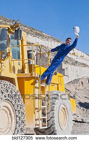 worker waving hard hat climbing mining machine View Large Photo Image Stock Photography - worker waving hard hat climbing mining machine. Fotosearch