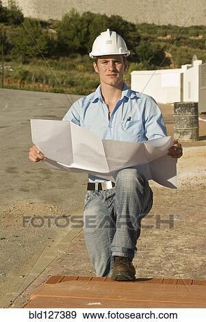 Young architect with plan on construction site View Large Photo Image Stock Photo - Young architect with plan on construction site. Fotosearch