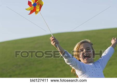 young girl with wind wheel running in green fields View Large Photo Image Stock Image - young girl with wind wheel running in green fields. Fotosearch