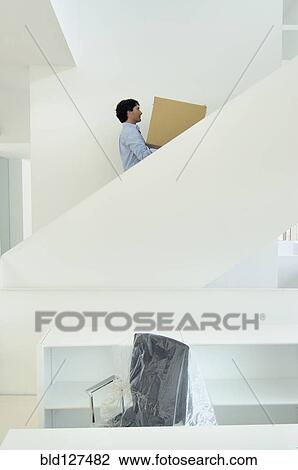 Young man carrying box upstairs side view View Large Photo Image Stock Image - Young man carrying box upstairs side view. Fotosearch