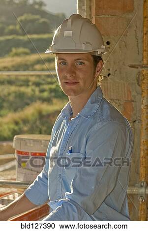 Young man wearing hardhat portrait View Large Photo Image Stock Image - Young man wearing hardhat portrait. Fotosearch