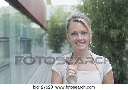 young woman hlding pen looking to camera View Large Photo Image Stock Image - young woman hlding pen looking to camera. Fotosearch