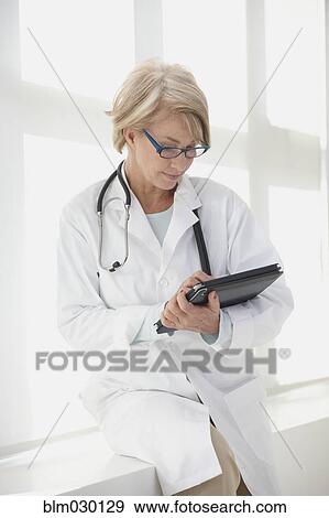 Caucasian doctor using digital tablet in hospital View Large Photo Image Stock Photo - Caucasian doctor using digital tablet in hospital. Fotosearch