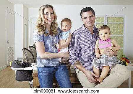 Stock Image - Caucasian family smiling in dining room. Fotosearch