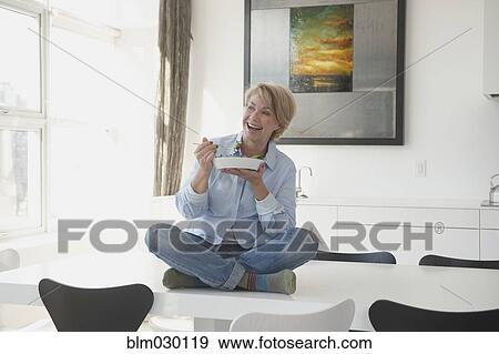 Caucasian woman eating on dining table View Large Photo Image Stock Photo - Caucasian woman eating on dining table. Fotosearch