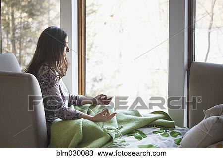 Caucasian woman meditating on sofa View Large Photo Image Stock Image - Caucasian woman meditating on sofa. Fotosearch