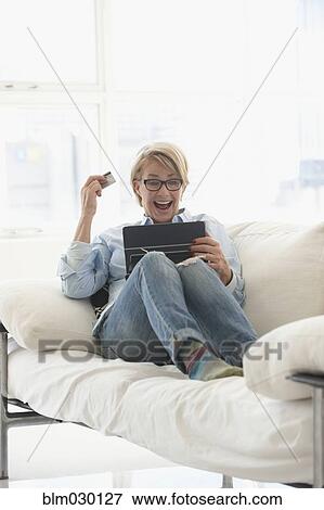 Stock Photo - Caucasian woman shopping on digital tablet. Fotosearch