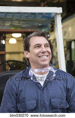 Caucasian worker smiling in warehouse View Large Photo Image Stock Image - Caucasian worker smiling in warehouse. Fotosearch