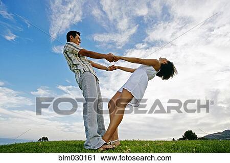 Stock Image - Couple playing in rural landscape. Fotosearch
