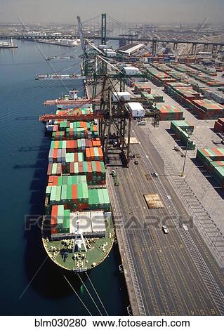 Stock Image - Cranes over container ship at commercial dock, Port of Los Angeles, California, United States. Fotosearch