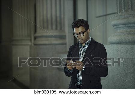 Man using cell phone on city street View Large Photo Image Stock Photography - Man using cell phone on city street. Fotosearch