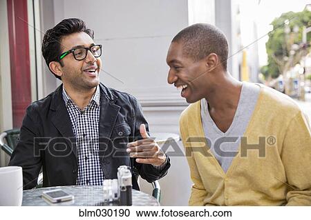 Stock Image - Men talking at sidewalk cafe. Fotosearch