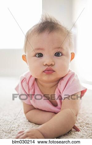 Mixed race baby girl laying on carpet View Large Photo Image Picture - Mixed race baby girl laying on carpet. Fotosearch