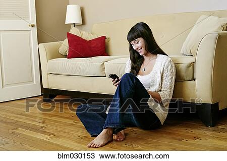 Stock Image - Mixed race woman using cell phone. Fotosearch