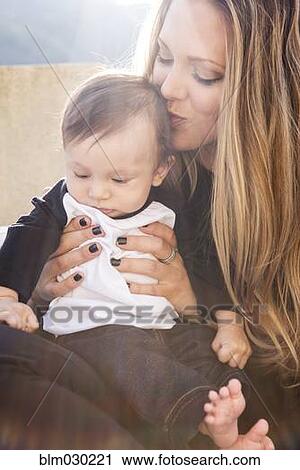 Mother kissing baby boy outdoors View Large Photo Image Stock Image - Mother kissing baby boy outdoors. Fotosearch