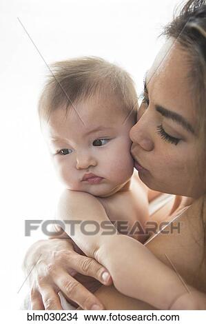 Mother kissing baby girl's cheek View Large Photo Image Picture - Mother kissing baby girl's cheek. Fotosearch