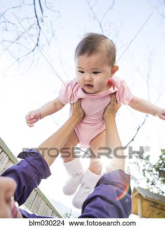 Mother playing with baby girl outdoors View Large Photo Image Picture - Mother playing with baby girl outdoors. Fotosearch