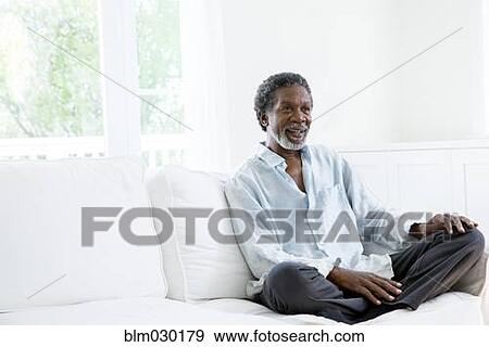Stock Photo - Senior man relaxing on sofa. Fotosearch