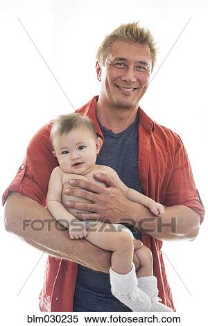Stock Photography - Smiling father holding baby. Fotosearch
