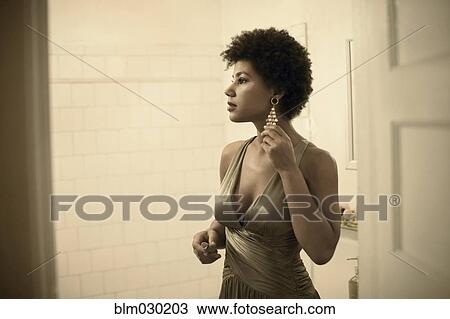 Stock Image - Woman getting ready in bathroom. Fotosearch