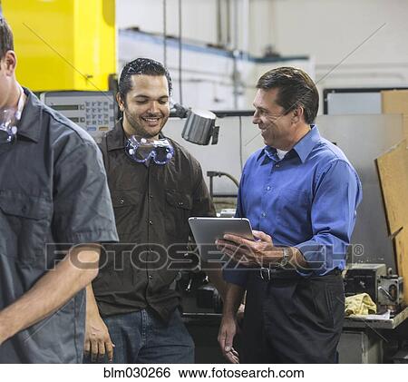 Worker and manager using digital tablet in warehouse View Large Photo Image Stock Photograph - Worker and manager using digital tablet in warehouse. Fotosearch