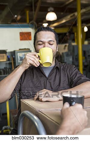 Worker drinking coffee in warehouse View Large Photo Image Stock Image - Worker drinking coffee in warehouse. Fotosearch