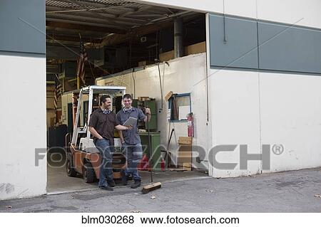 Workers using digital tablet at warehouse loading dock View Large Photo Image Stock Photo - Workers using digital tablet at warehouse loading dock. Fotosearch