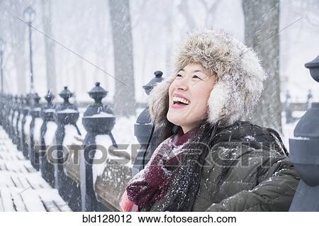 Asian woman sitting on park bench in snow View Large Photo Image Stock Image - Asian woman sitting on park bench in snow. Fotosearch