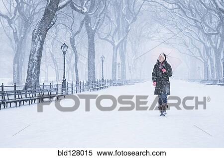 Stock Photography - Asian woman walking in snowy park. Fotosearch