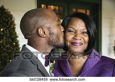 Black groom kissing mother at wedding View Large Photo Image Stock Photo - Black groom kissing mother at wedding. Fotosearch