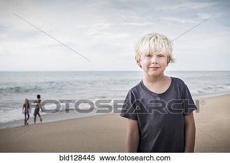 Stock Photography - Boy smiling on beach. Fotosearch
