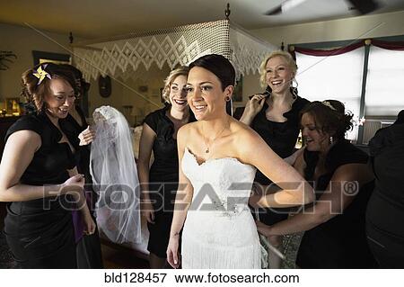 Bridesmaids helping bride get ready View Large Photo Image Stock Photo - Bridesmaids helping bride get ready. Fotosearch