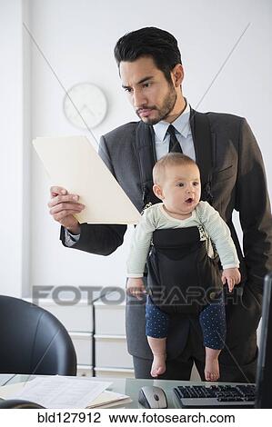 Businessman working with baby in office View Large Photo Image Stock Image - Businessman working with baby in office. Fotosearch