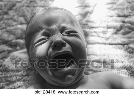 Stock Photo - Caucasian baby crying on bed. Fotosearch