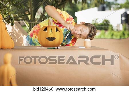 Caucasian boy decorating jack o'lantern View Large Photo Image Stock Image - Caucasian boy decorating jack o'lantern. Fotosearch