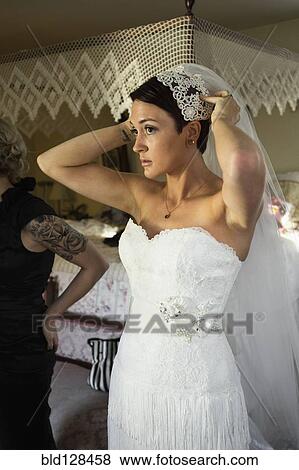 Stock Photo - Caucasian bride adjusting her veil. Fotosearch