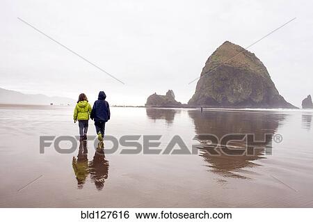 Stock Photograph - Caucasian children walking on beach, Cannon Beach, Oregon, United States. Fotosearch