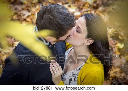 Caucasian couple kissing in autumn leaves View Large Photo Image Stock Image - Caucasian couple kissing in autumn leaves. Fotosearch