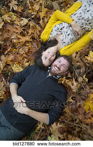 Caucasian couple smiling in autumn leaves View Large Photo Image Stock Image - Caucasian couple smiling in autumn leaves. Fotosearch