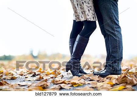 Stock Photo - Caucasian couple standing in autumn leaves. Fotosearch