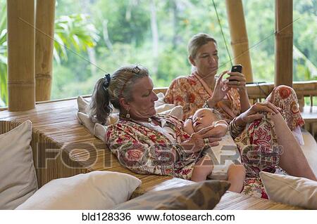 Stock Photograph - Caucasian family relaxing on outdoor patio. Fotosearch