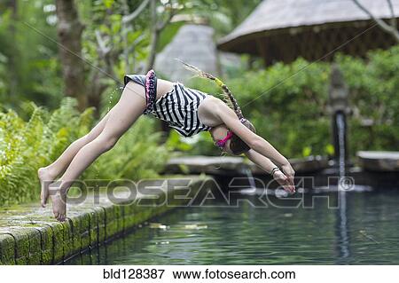 Stock Photo - Caucasian girl diving into swimming pool. Fotosearch
