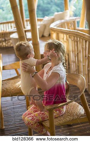 Stock Photograph - Caucasian girl holding baby boy. Fotosearch