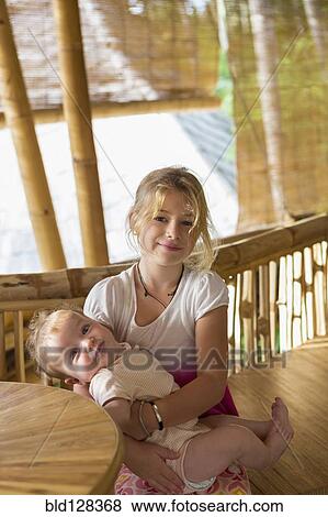 Stock Photo - Caucasian girl holding baby sibling. Fotosearch