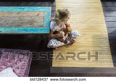 Stock Photo - Caucasian girl holding cat on patio. Fotosearch