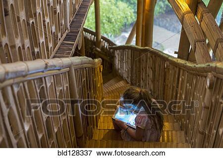 Stock Photo - Caucasian girl using digital tablet on steps. Fotosearch