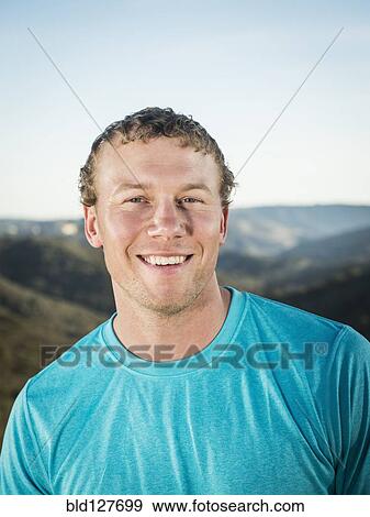 Stock Photo - Caucasian man smiling on hilltop. Fotosearch
