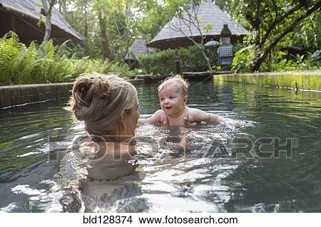 Caucasian mother and baby playing in pool View Large Photo Image Picture - Caucasian mother and baby playing in pool. Fotosearch