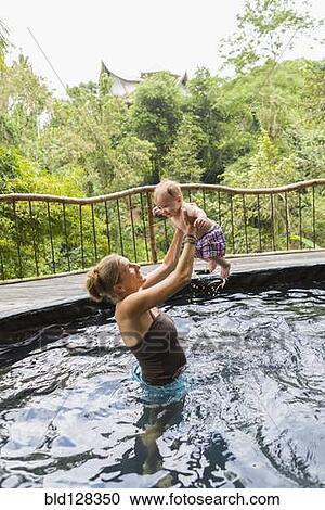 Caucasian mother and baby playing in pool View Large Photo Image Stock Image - Caucasian mother and baby playing in pool. Fotosearch
